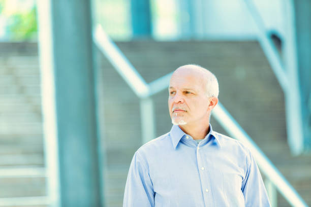 istock Businessman poses thoughtfully outside modern corporate building 2152708268
