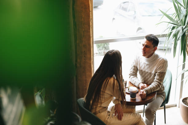 istock Man and Woman Sitting at Table Talking 2152713461