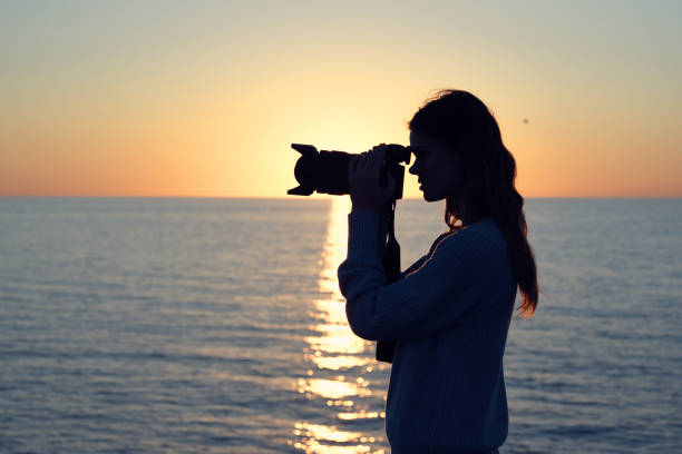 istock Woman with camera landscape sunset sea sun model 2152717675