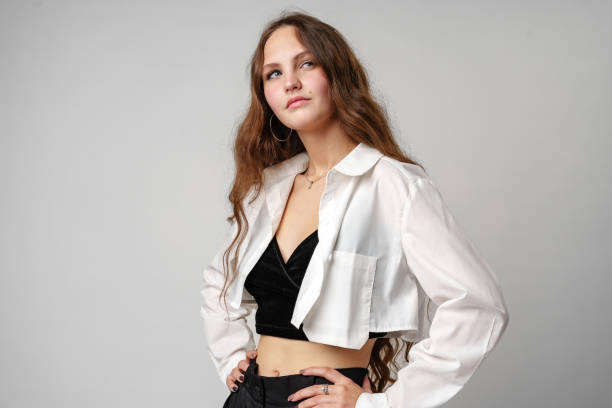 istock Confident Young Woman Posing in Stylish Outfit Against a Grey Backdrop 2152717714