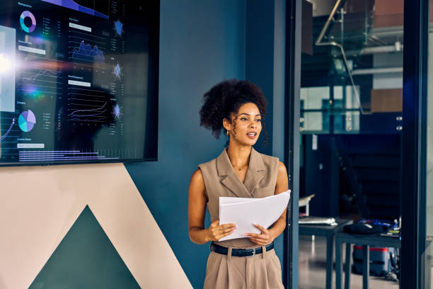 istock Professional African American woman presenting data on a digital display in a corporate office. Effective communication and data visualization concept 2152719779