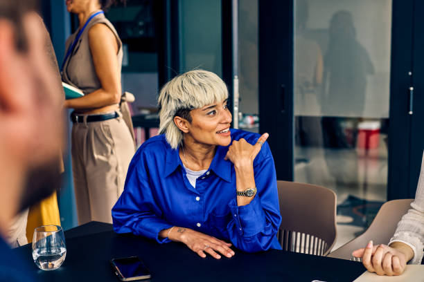 istock Gen Z co-worker discussing strategies with a colleague during a creative meeting. Multitasking and team collaboration in a diverse office environment concept. 2152719783