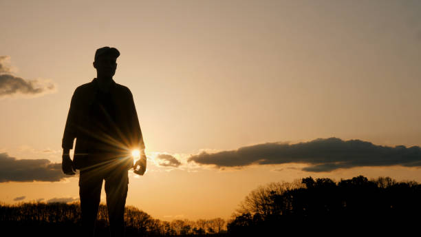 istock Silhouette of a man standing in front of a sunset 2152723096