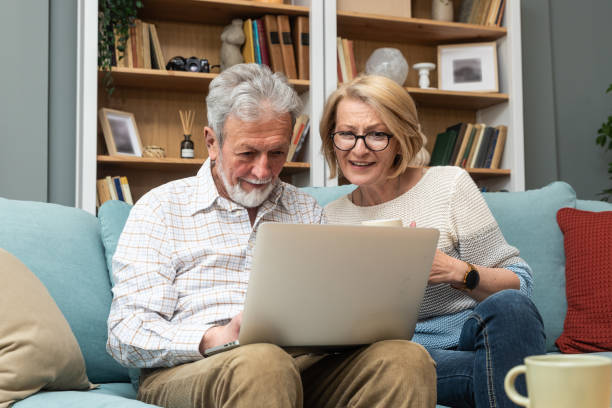 istock Simple living. Modern senior couple using laptop computer, searching the internet to find nice place for vacation. Older retired man and woman surfing the net for summer house on village to move. 2152726041