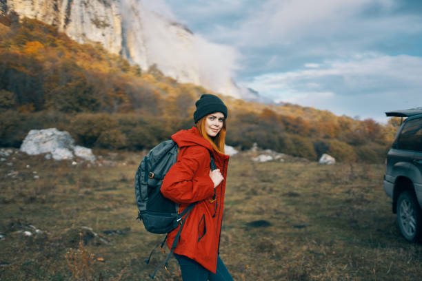 istock woman model In a red jacket with a backpack in the fall outdoors warm hat fallen leaves 2152727149