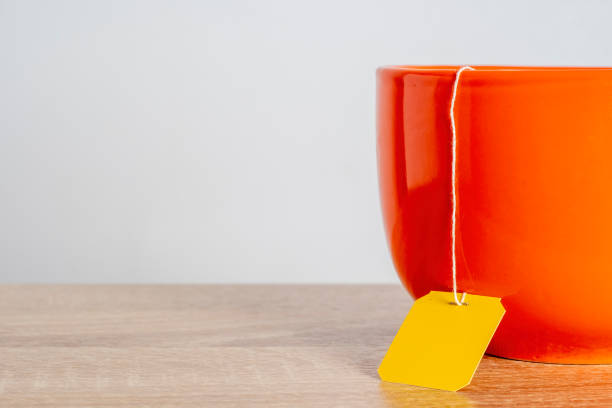 istock A tea bag with a blank yellow label in a cup. Cozy template with space for text on a tea bag tag. 2152730502