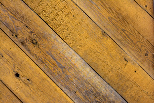 Background with wooden boards covered with peeling yellow paint.