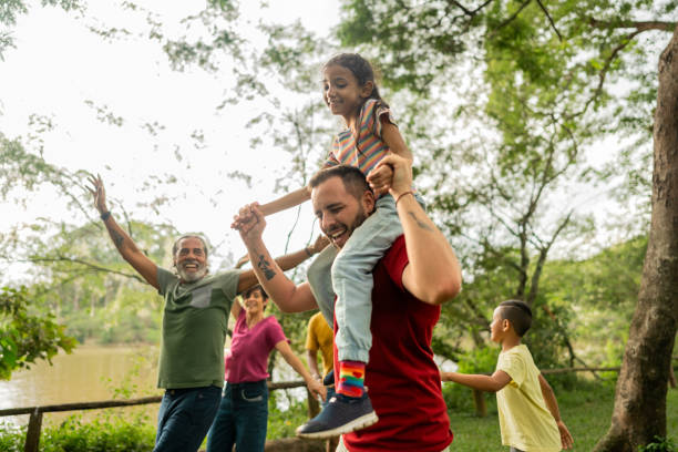 Step-father having fun during piggyback with adopted daughter on a public park