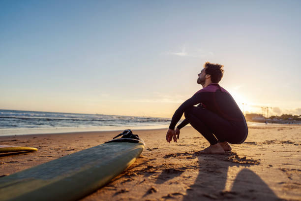 istock A surfer in crouching on a shore and looking at the ocean. 2152733245