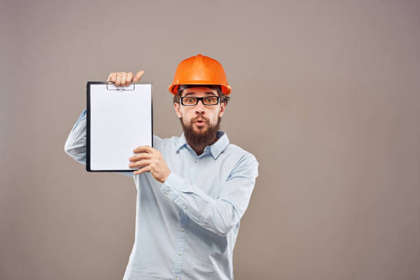 istock A man in a shirt with an orange hard hat engineer work documents rendering services 2152734107