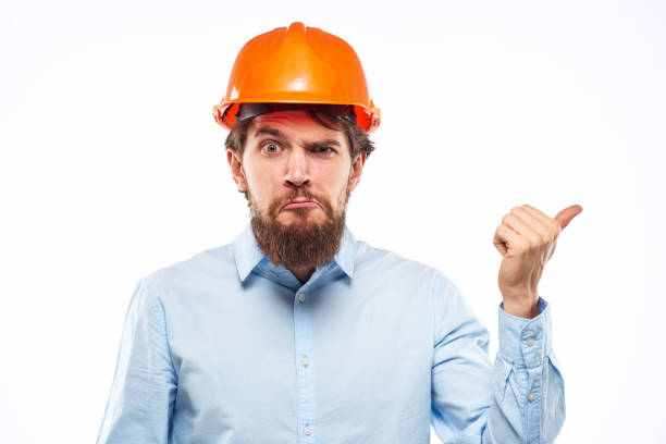 A man gestures with his hands an engineer orange hard hat safety construction. High quality photo