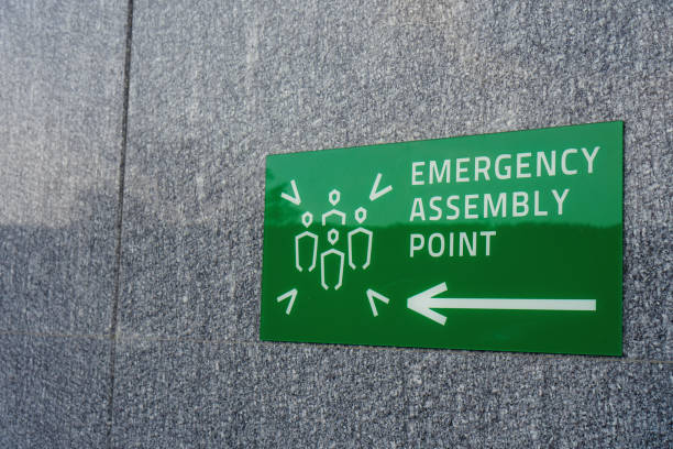 istock Emergency sssembly point sign on the textured wall. Assemble here for safety 2152738303