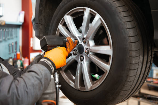 istock Unrecognizable mechanic unscrewing car wheel with tool 2152738632