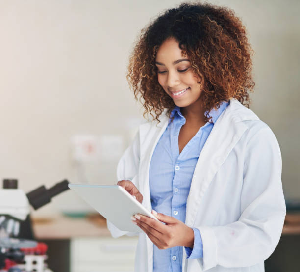 istock Scientist, reading and woman in lab with tablet for test, data or study research info online for vaccine. Science, tech and person check results of medical experiment or analysis of virus or bacteria 2152738822