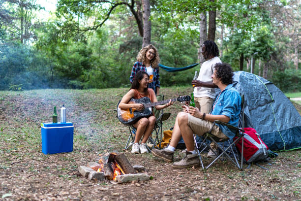 istock Young multiracial friends singing and playing a guitar in forest 2152740275