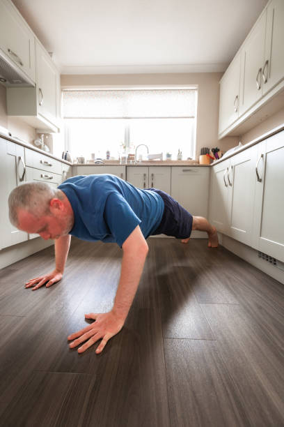 istock Mid adult man doing push-ups on kitchen floor 2152748203