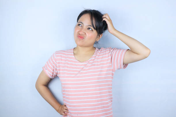 istock Confused expression of beautiful Asian woman scratching her head while looking up 2152750970