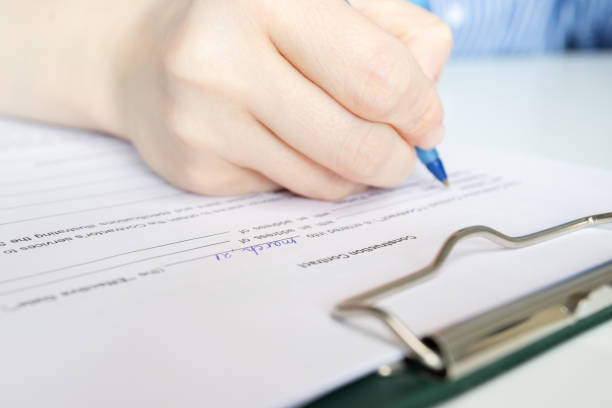 istock Construction contract, hand fills out a document, housing project planning session, apartment purchase agreement signing 2152751525