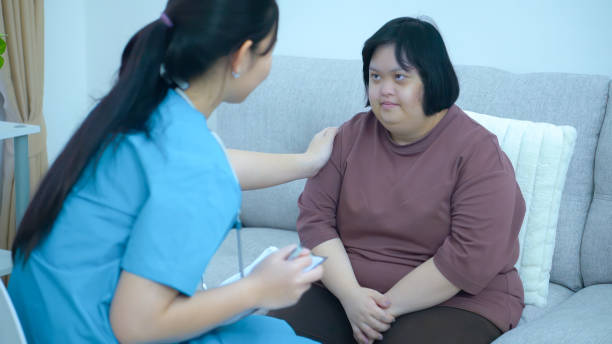 istock Asian female doctor Keep notes on caring for a patient with Down Syndrome at home. 2152755929