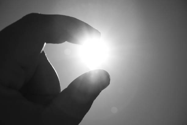 Cropped hand against the sun