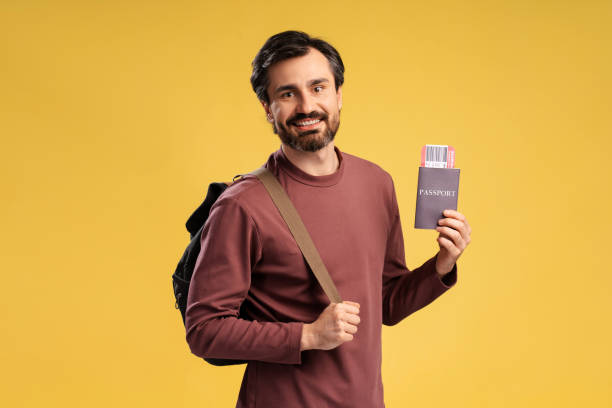 istock Happy young man showing ticket and passport, posing with backpack, isolated 2152760642