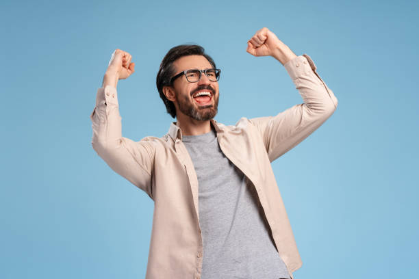 Excited bearded man gesturing happiness isolated on blue background