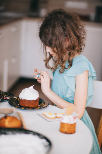 A girl decorates traditional Ukrainian pastries for Easter.