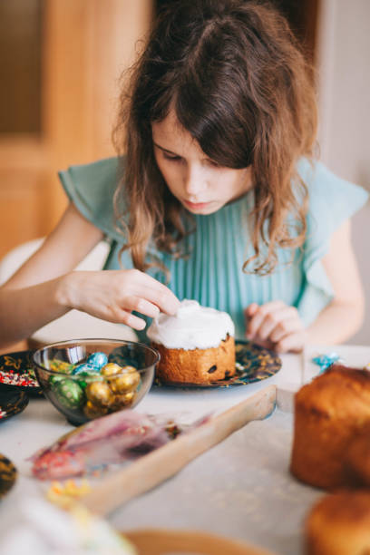 A girl decorates traditional Ukrainian pastries for Easter.
