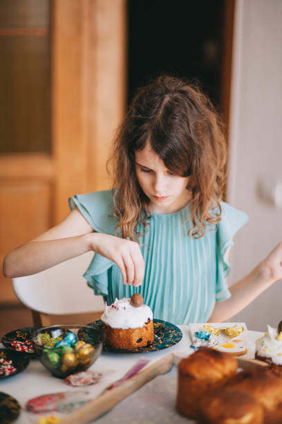 A girl decorates traditional Ukrainian pastries for Easter.