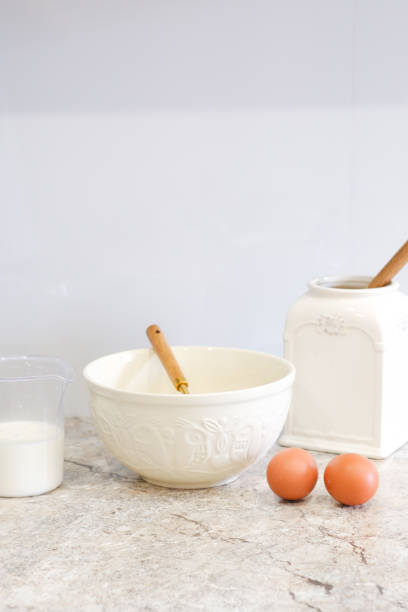 istock Home kitchen interiorBowl with dough, milk, eggs and bowl of sugar on kitchen table in modern kitchen. 2152763872
