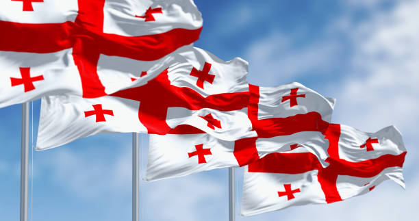 National flags of Georgia waving in the wind on a clear day National flags of Georgia waving in the wind on a clear day. White with a red cross, four smaller crosses in each quadrant. 3d illustration render. Fluttering fabric. Selective focus georgia flag country stock pictures, royalty-free photos & images