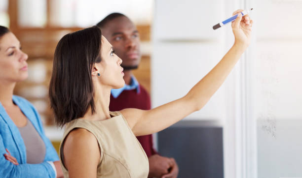 istock Writing, business people and problem solving in office for brainstorming, ideas or planning in meeting. Creative employees, diversity and teamwork on glass board for strategy, solution or schedule 2152771276