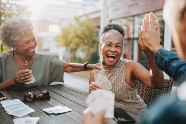 amigas mayores jugando a las cartas - cartas de mejores amigas fotografías e imágenes de stock