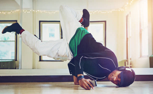 istock Hip hop, dancer and practice performance in class with phone, music and motion for skill, training and art of dancing. Man, headphones and podcast for streetwear, energy and competition battle 2152777848