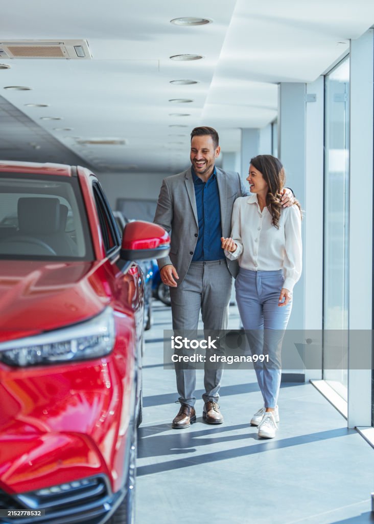 Beautiful young couple at car showroom choosing a new car to buy - Royalty-free Auto Stockfoto Beautiful young couple at car showroom choosing a new car to buy - Royalty-free Auto Stockfoto
