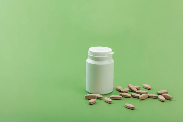 Dietary supplements Artichoke leaf extract capsules. Alternative medicine, herbal lifestyle, healthy self care. Savannah green trendy background, flat lay, copy space