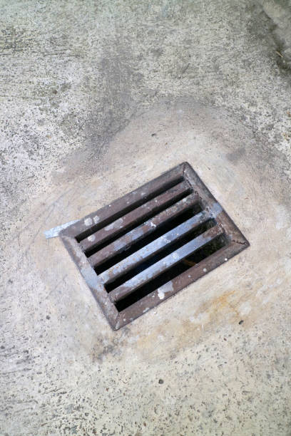 istock an iron gutter cover, with a rust color. Box shaped. on a concrete road 2152779880