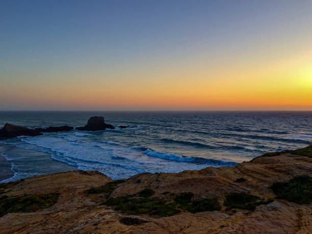 istock The image captures a beautiful sunset over a rugged coastline with waves crashing against the rocks. 2152785466
