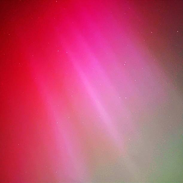 istock The Aurora Borealis Over South Wales Dark pinks, medium pinks and light pinks, mint green, light green, medium green and dark greens with stars showing through the auroral colours 2152789155