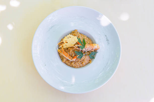 Delicately served risotto with shrimp and cracker pieces.
