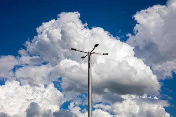 Sky with fluffy clouds with blue background and street lamp