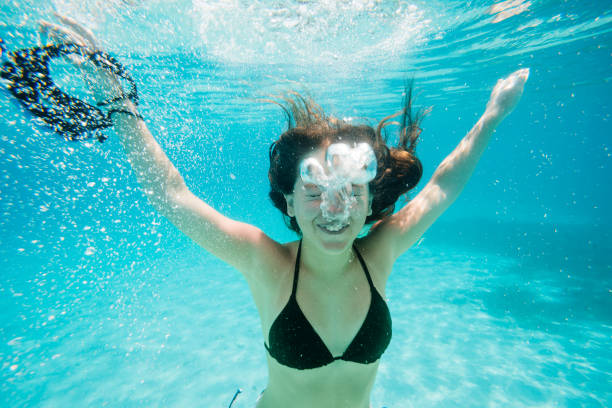 istock Smiling young girl diving underwater 2152790592
