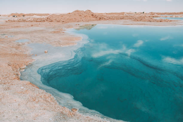 Serene salt lake under wispy clouds in Siwa Oasis, Egypt.