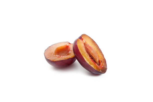 Juicy summer plum fruit. Halves ripe sweet plum isolated on white background.