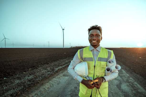istock Engineer with reflective vest posing for a shot with wind turbines at the background 2152802975