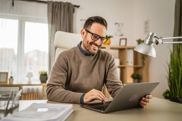 istock One adult man sit at office and look, read document on laptop at office 2152803469