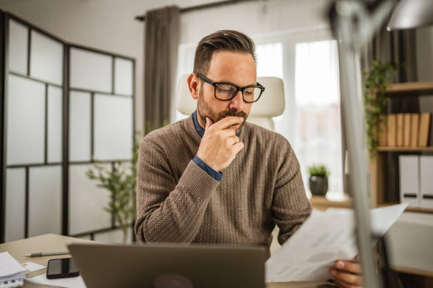 istock Adult businessman sit at office hold and read, think about document 2152803770