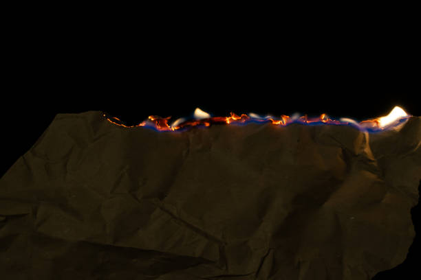 istock burning paper, glowing edge of paper on a black background 2152803811