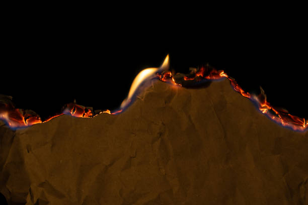 istock burning paper, glowing edge of paper on a black background 2152803824