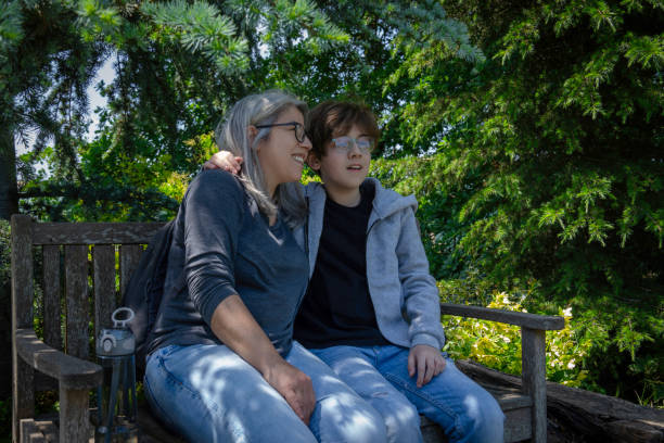 istock Mother and son are sitting on a bench in the forest. 2152804797